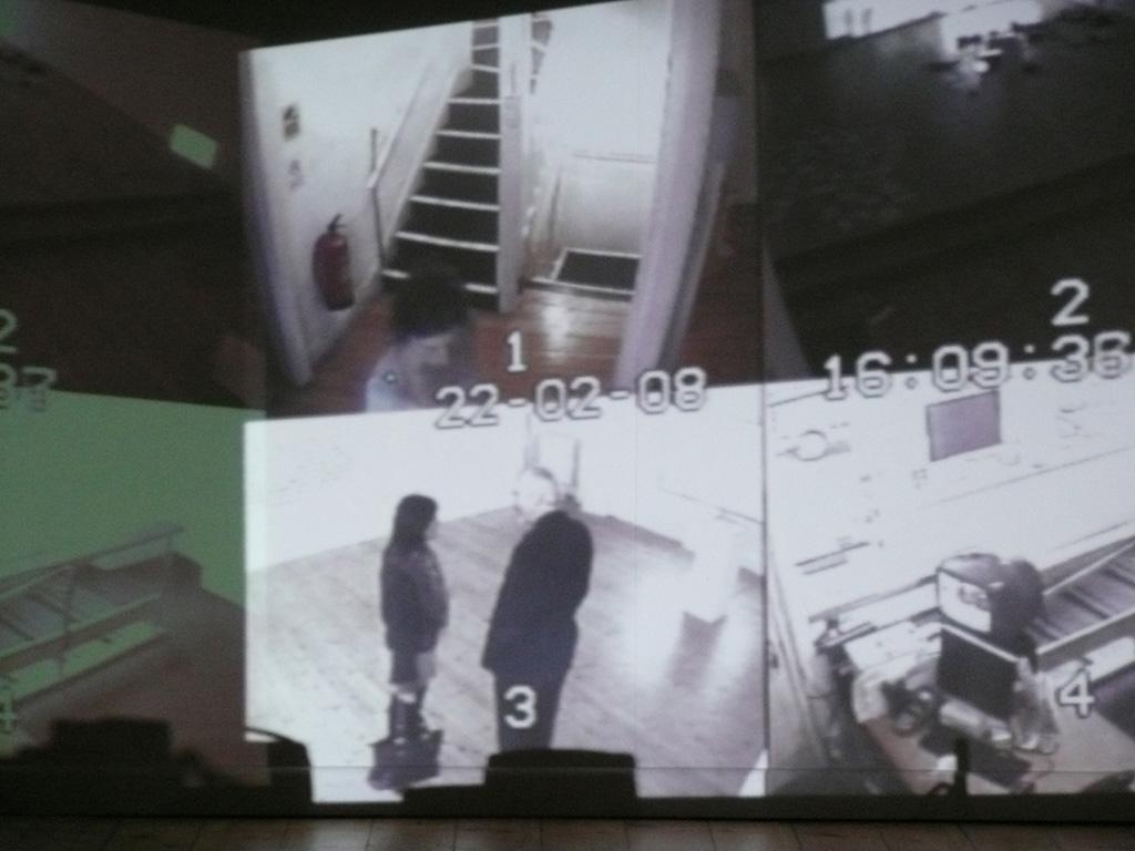 A surveillance system that incorporates the visitors to the gallery inside the artwort, as a performative spectacle of surveillance.  